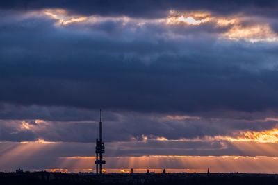 Silhouette tower against dramatic sky during sunset