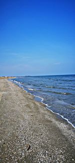 Scenic view of beach against clear blue sky