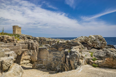 Rock formations on beach against sky