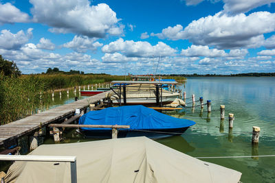 Boats moored in lake against sky