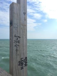 Pier on sea against cloudy sky