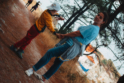 Tilt image of woman with son standing on field