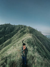 Man standing on mountain against sky