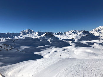 Scenic view of snowcapped mountains against clear blue sky