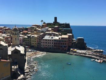 High angle view of buildings by sea against clear sky