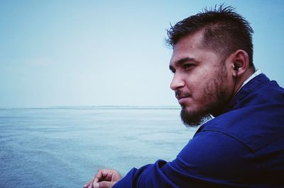 Portrait of mid adult man in sea against clear sky