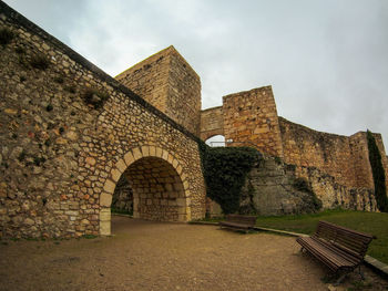 Stone wall of old building against sky