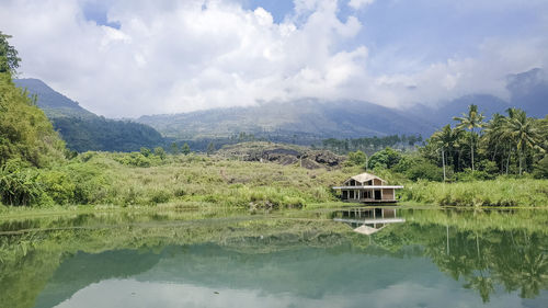 Scenic view of lake by mountains against sky