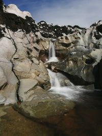 Scenic view of waterfall against sky