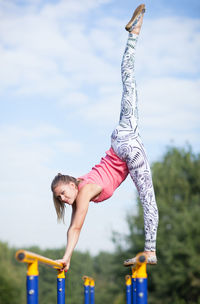 Low angle view of woman exercising at playground