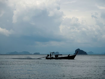 Fishing boat in sea against sky