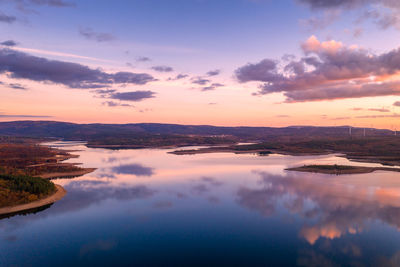 Drone aerial view of a lake reservoir of a dam with reflection on the water in sabugal, portugal