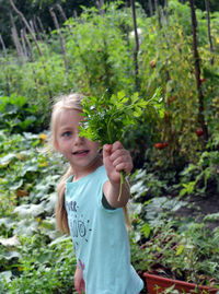 Portrait of smiling girl standing against plants