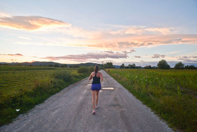 Rear view of woman walking on road