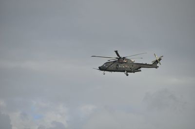 Low angle view of helicopter flying in sky