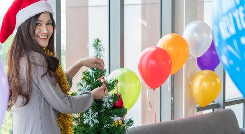 Smiling young woman holding balloons