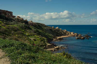 Scenic view of sea and cliff against sky