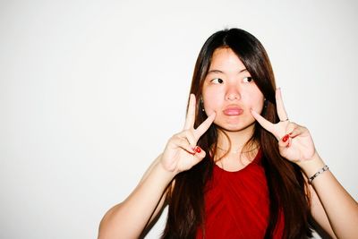 Portrait of beautiful young woman against white background