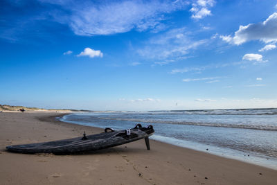 Scenic view of beach against blue sky