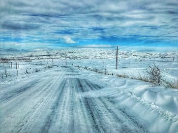 Snow covered road against sky