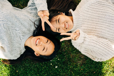 High angle portrait of smiling young woman lying on ground