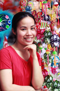 Portrait of smiling young woman standing against decorations