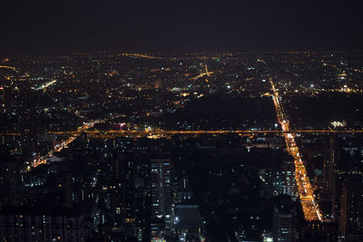 High angle view of illuminated cityscape against sky at night