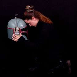 Young woman holding camera over black background