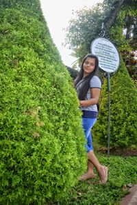 Portrait of smiling woman standing against plants