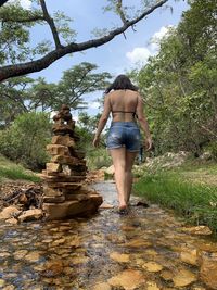 Rear view of woman standing on rock