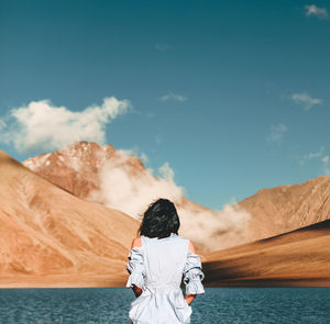 Rear view of woman standing against sky