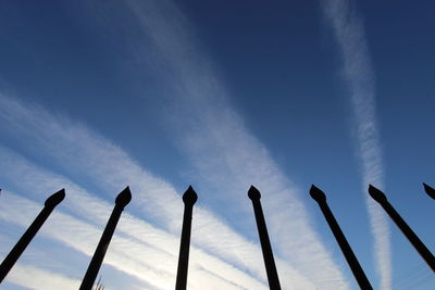 Low angle view of silhouette trees against blue sky