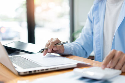 Midsection of doctor working on table