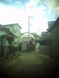 Alley amidst buildings in city against sky