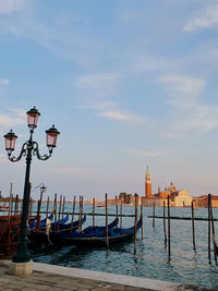 View of wooden post in canal against sky