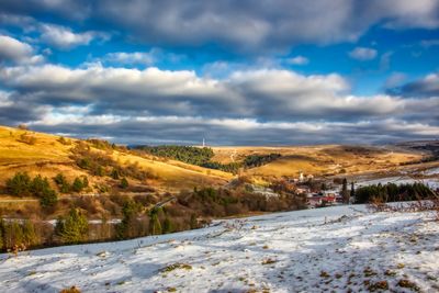 Scenic view of snow covered land against sky