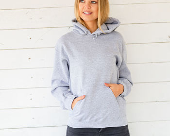 Portrait of smiling young woman standing against wall