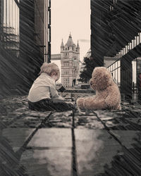 Full length of child sitting in city