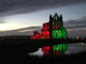 View of illuminated building against cloudy sky