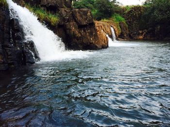 Scenic view of waterfall against sky