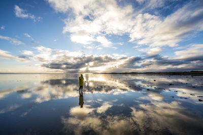 Pretty woman poses in the middle of the reflected sea.