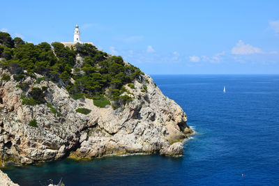 Scenic view of sea by rock formation against sky