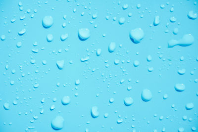 Full frame shot of raindrops on blue window