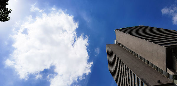 Low angle view of skyscrapers against blue sky