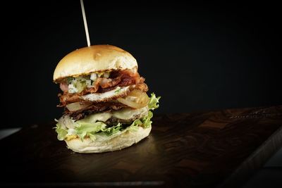 Close-up of burger against black background