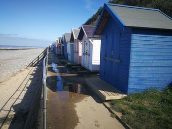 Buildings on beach against blue sky