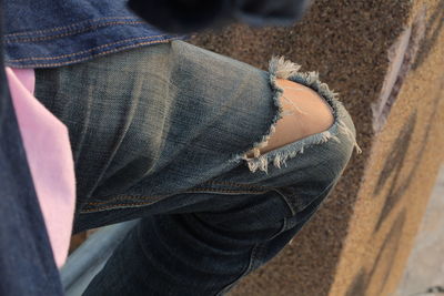 Midsection of person wearing torn jeans