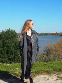 Woman standing by plants against sky