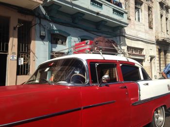 Red car on street against buildings