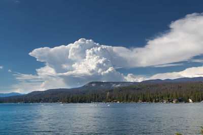 Scenic view of lake and mountains against blue sky